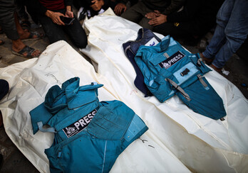 Los chalecos de dos periodistas muertos en ataques israelíes, sobre sus restos. 